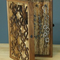 Necklaces hang from hand-carved walnut hooks.