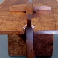 Tops fitted into grooves in the cross-piece trestle and buttery walnut curves.