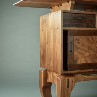 Through dovetails and mortise-and-tenon joints complement Chinese legs and a floating top.
